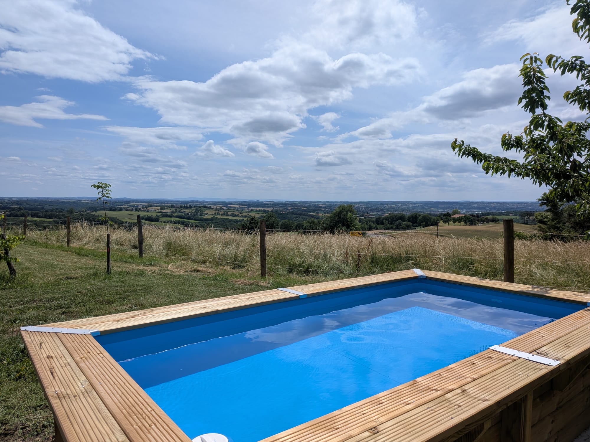Piscine extérieure avec vue dégagée sur la campagne du Tarn depuis une chambre d’hôtes en pleine nature.